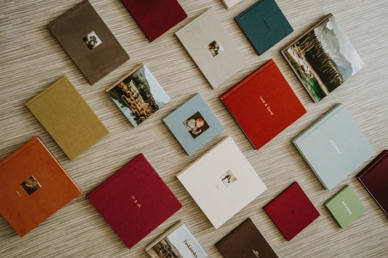 Kvalitní Fotky photo books in assorted cover colours, photographed from above.